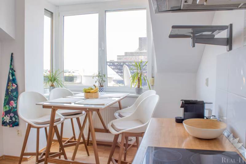 A bright kitchen in a 3-room apartment with a bar table and a view of the city.
