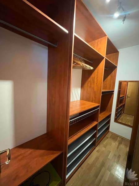 A wooden wardrobe with shelves and a mirror in a 3-room apartment.