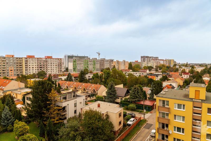 View of Hraničná Street in Bratislava - Ružinov with apartment buildings and greenery.