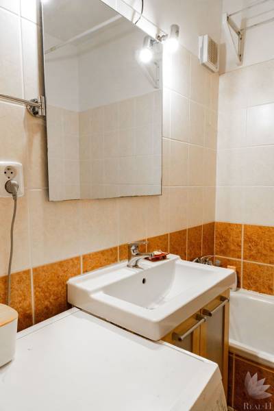 A bathroom with a mirror and a sink in a 2-room apartment.