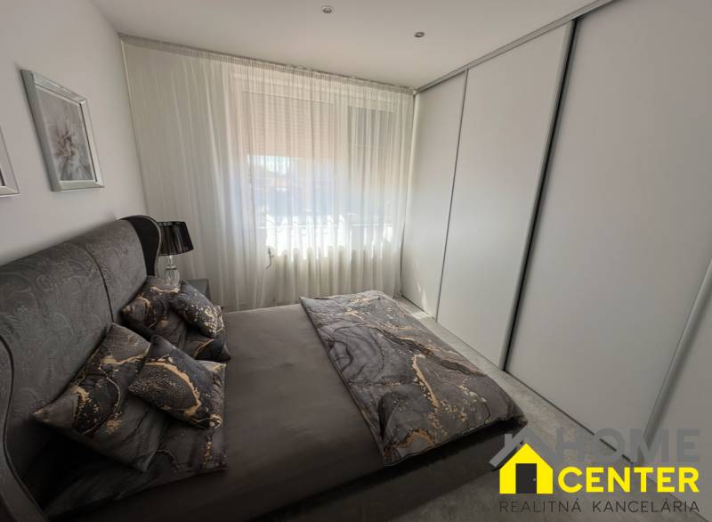 A bedroom in a family house with dark bedding and a large wardrobe.