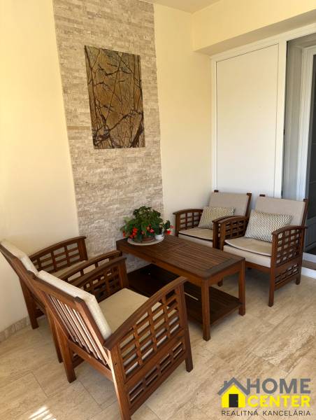 Seating on the terrace of a family house with wooden furniture and wall decoration.