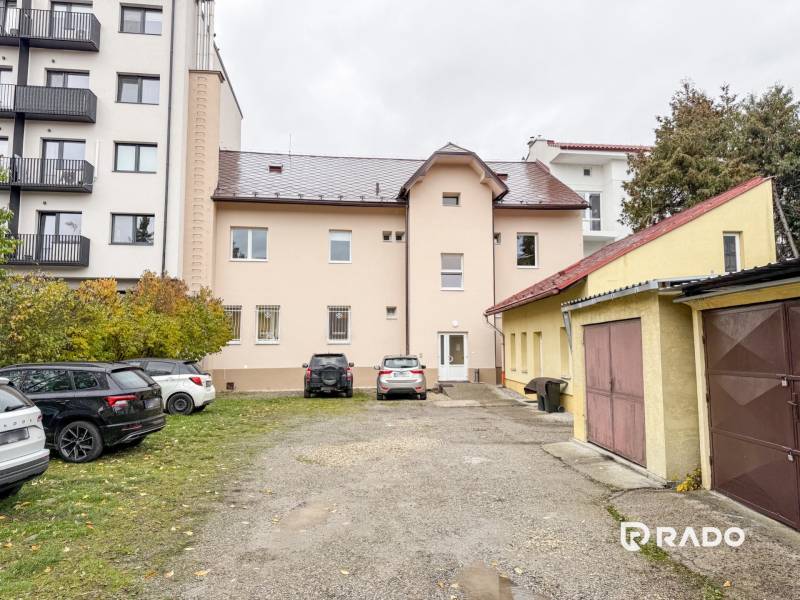 The building on Bratislavská Street in Žilina, surrounded by cars and garages, suitable for offices.