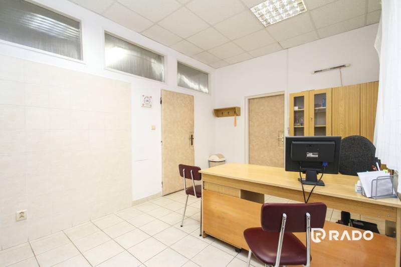 Office with a desk, chair, computer, and cabinet on a light ceramic floor.