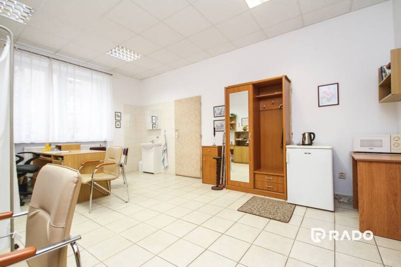 Office with furniture, a desk, chairs, and a sink.