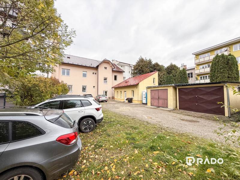 Parking lot near the offices on Bratislavská Street in Žilina, cars and garages in the background.