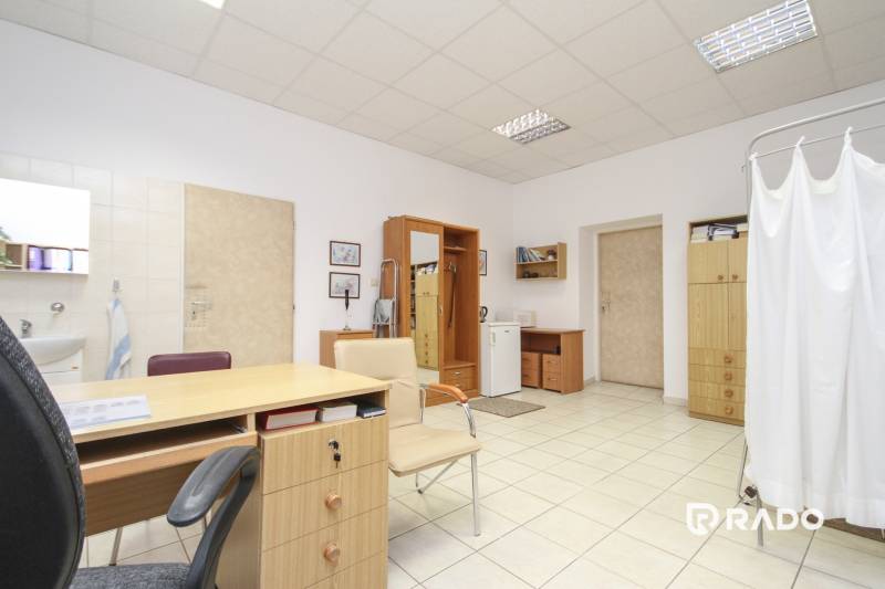 Offices with furniture and a sink, a bright space with tiled flooring.
