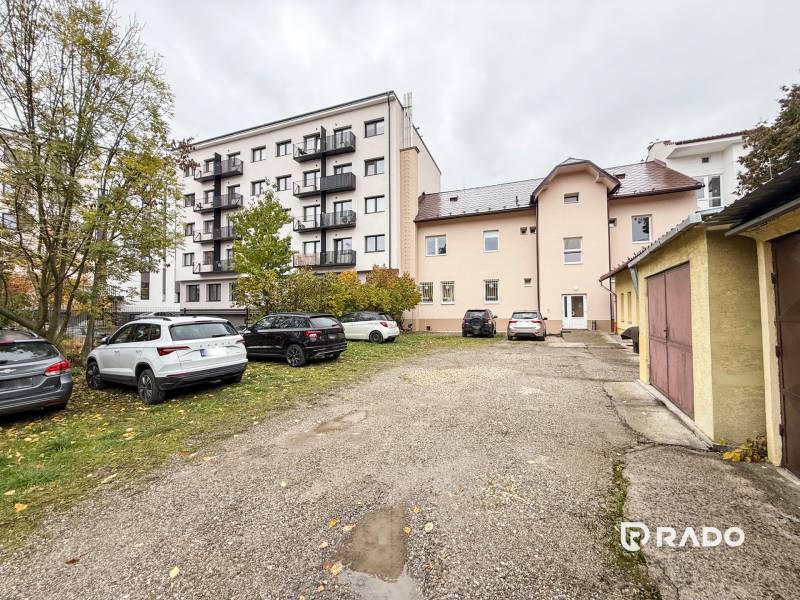 Parking lot and buildings on Bratislavská Street in Žilina, offices and residential buildings.