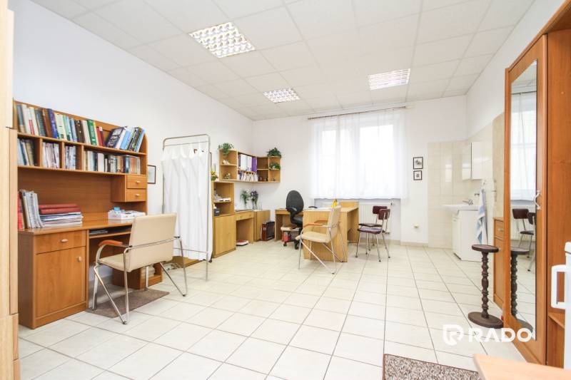 Offices with desks and chairs, white ceramic floor, shelves with books.