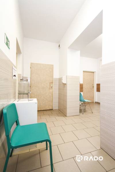 Waiting room in offices with turquoise chairs and light walls.