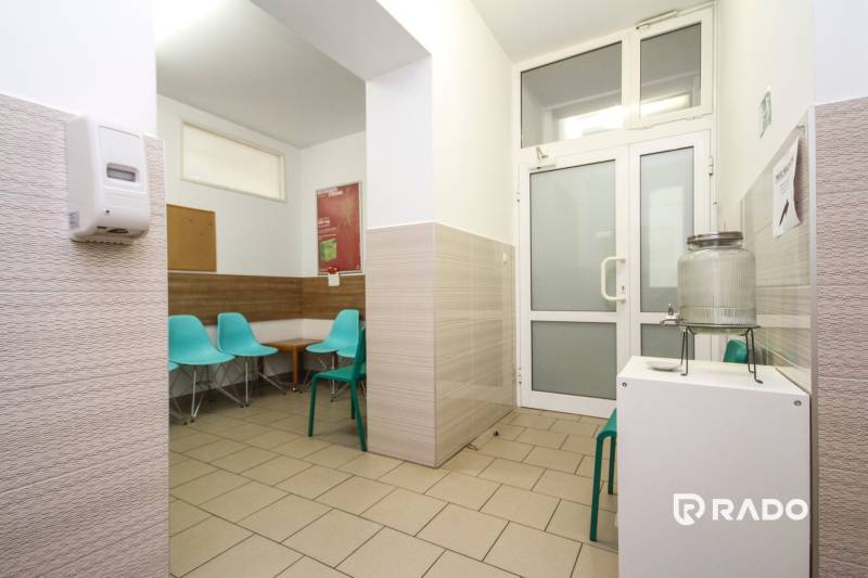 A waiting room in an office with turquoise chairs and a water dispenser.