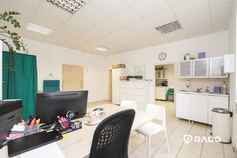 Office with furniture, computer, and kitchenette, with tiles on the floor.