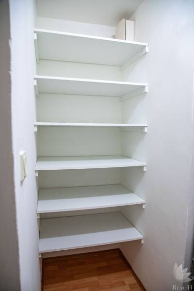 White multi-level storage shelf in a 2-room apartment, floor with wood decor.