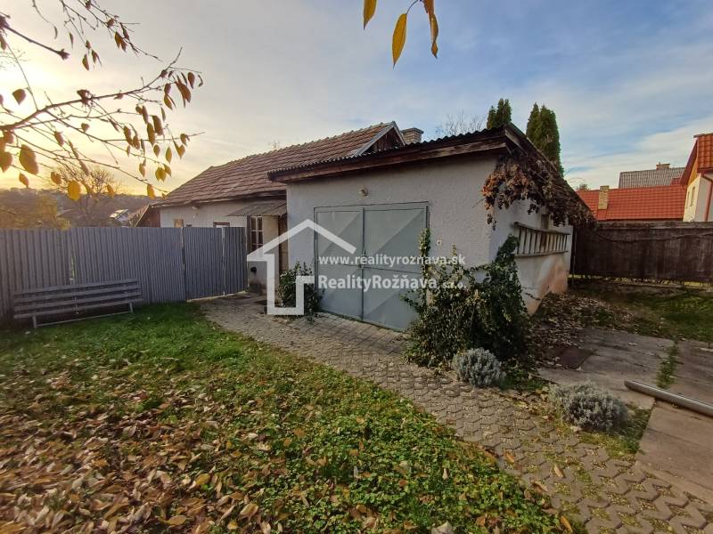 A family house in Dlhá Ves with a courtyard, lawn area, and garage surrounded by a fence.