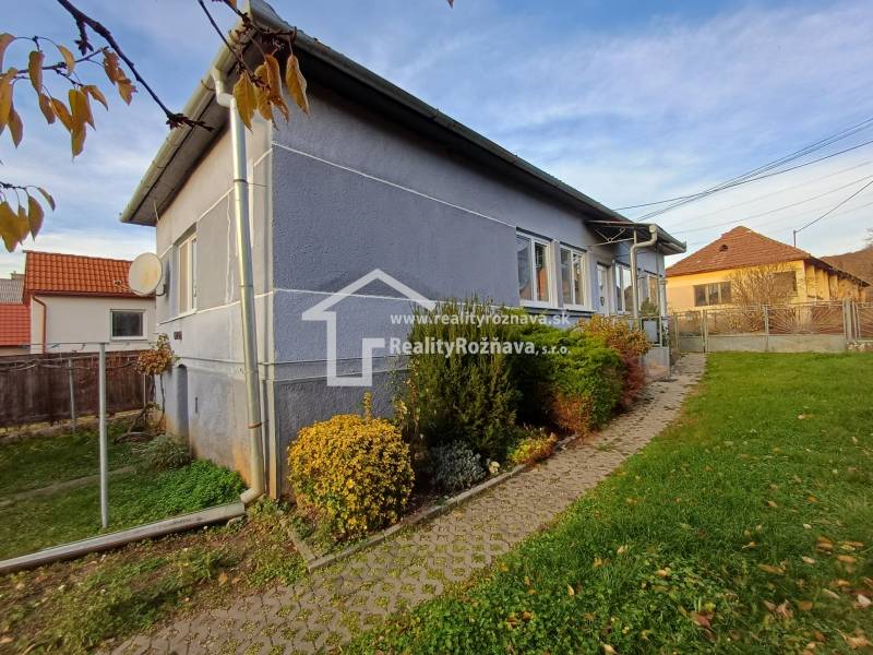 A family house in Dlhá Ves, a garden with shrubs, paving leading to the entrance.