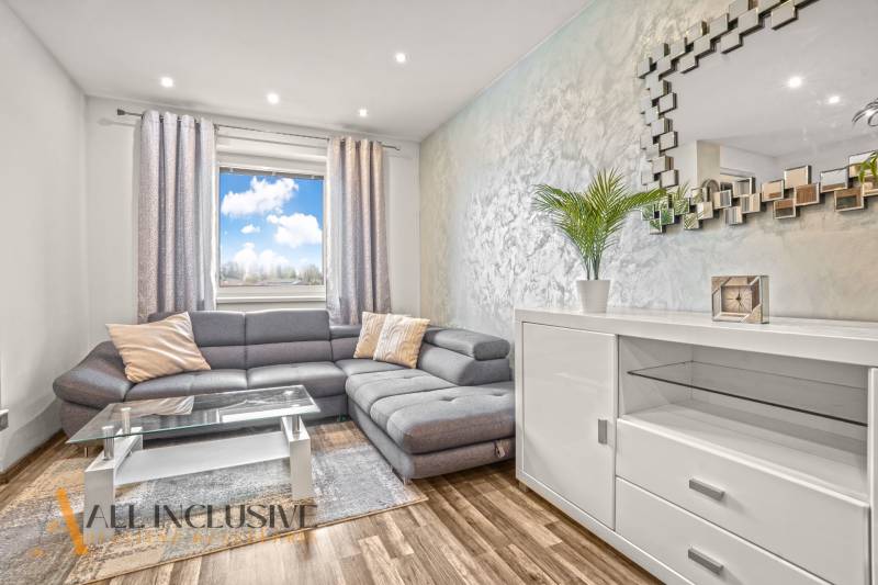 Living room in a 3-room apartment with a comfortable sofa and a wooden decor floor.