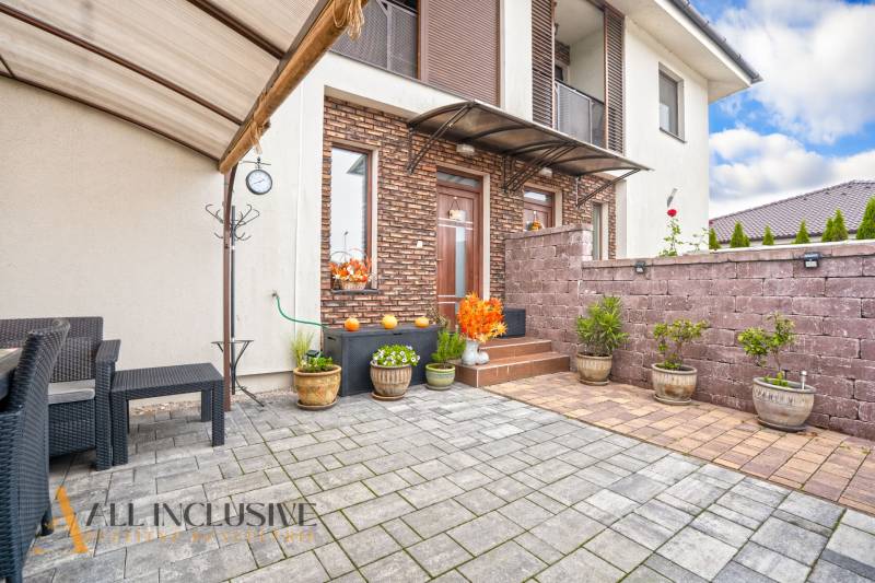 Terrace of a 3-room apartment in Gabčíkovo with tiles and flower pots, along the brick cladding.