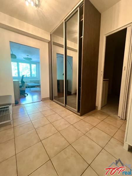 A hallway with a tiled floor and a built-in wardrobe in a 3-room apartment.