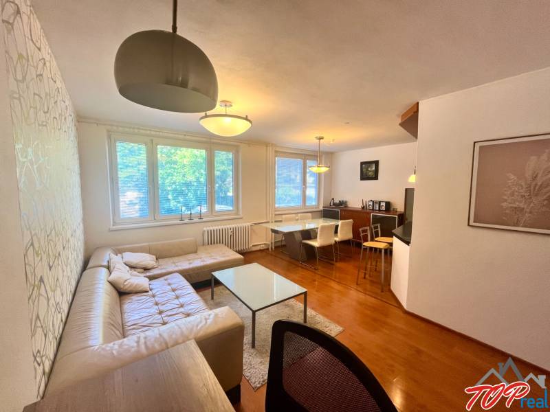 Living room in a 3-room apartment with a sofa, table, and dining area.