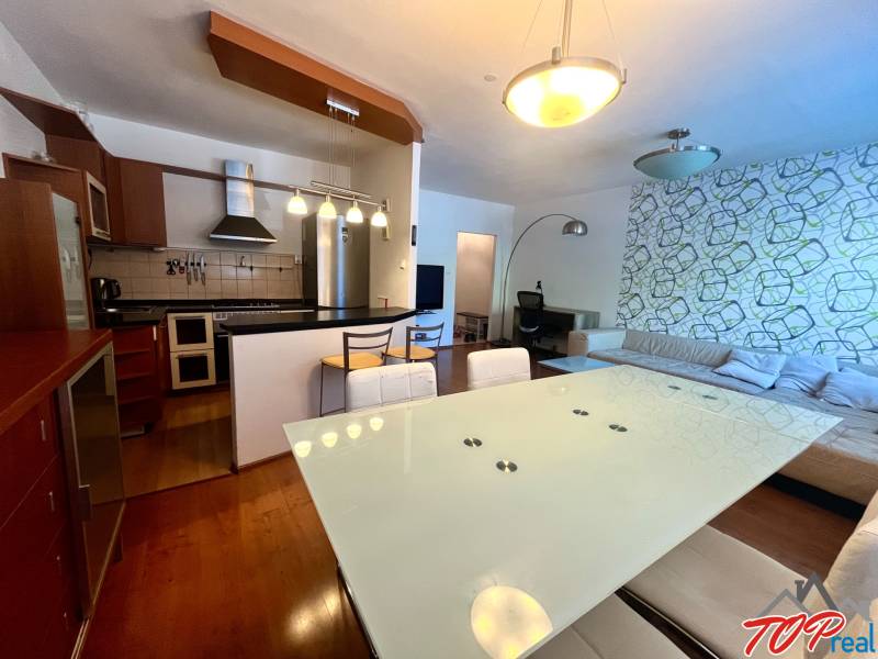 The kitchen and living room in a 3-room apartment with modern furniture and a decorative wall.