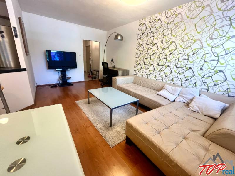 Living room with a beige sofa and a television in a three-room apartment.