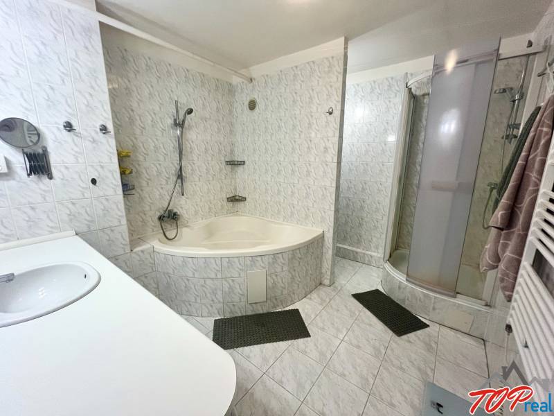 A bathroom in a 3-room apartment with a bathtub, shower, and sink.