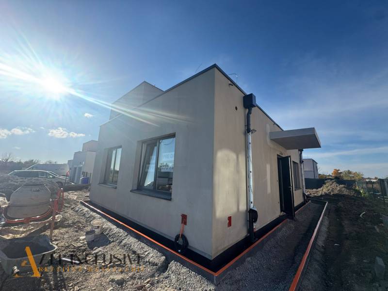 The exterior of a family house in Hubice during construction, sunny weather brightens the scene.