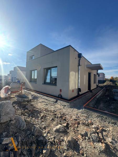 A family house under construction in Hubice with unlandscaped terrain. Clear sky and sunlight.