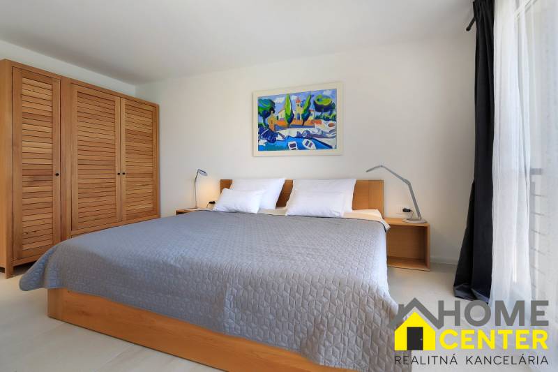 Bedroom in a villa with a large bed, wooden wardrobe, and a painting on the wall.