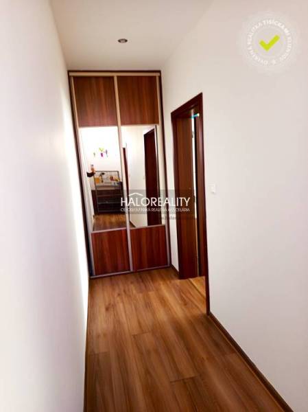 A hallway in a 3-room apartment with a wooden decor floor and a built-in wardrobe.