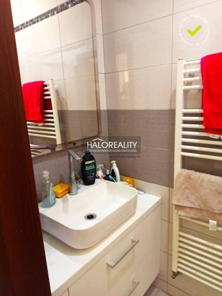 A bathroom in a 3-room apartment with a mirror, sink, and ladder radiator.