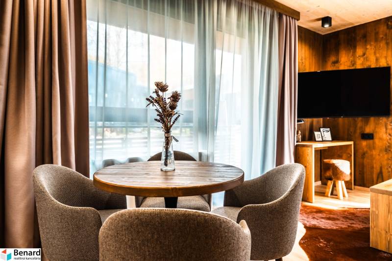 Dining area in a 2-room apartment with a wooden decor floor and a view from the window.