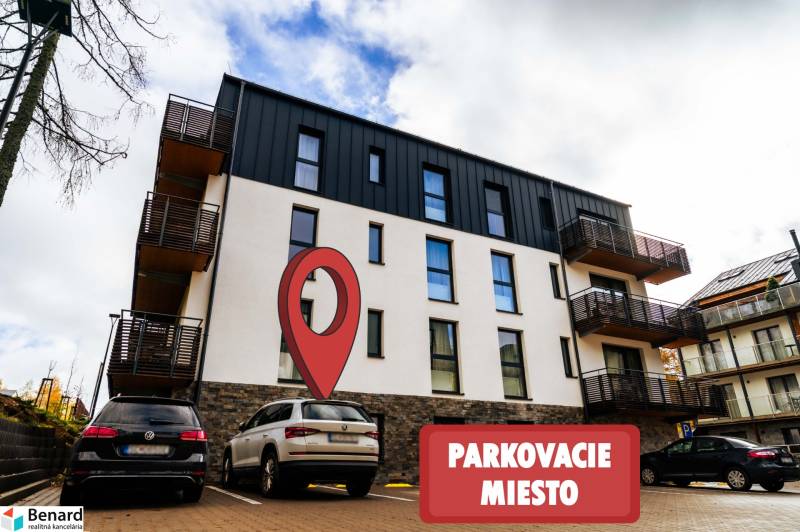 Apartment building on Lúčná Street in Štrba with a marked parking space in the foreground.