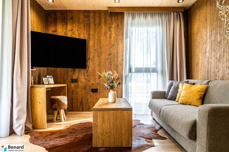 Living room in a 2-room apartment with a sofa, wood-patterned flooring, and a coffee table.