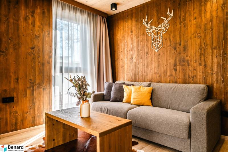Living room in a two-room apartment with a wooden decor floor and wall decoration.