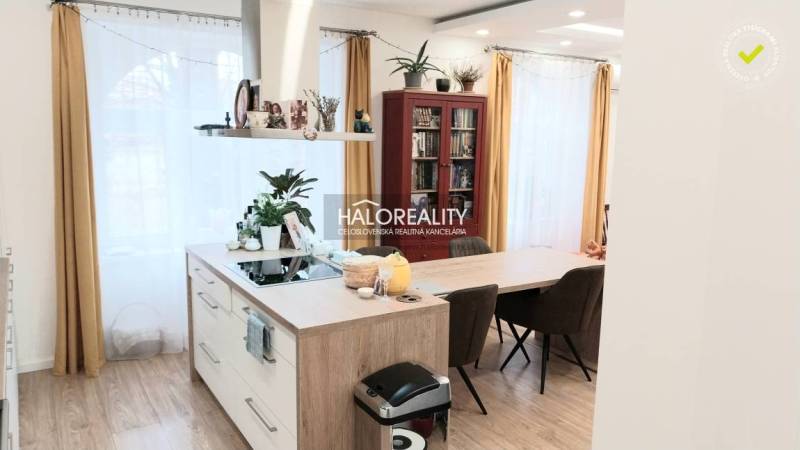 Modern kitchen in a 3-room apartment with an island and flooring with a wood decor.