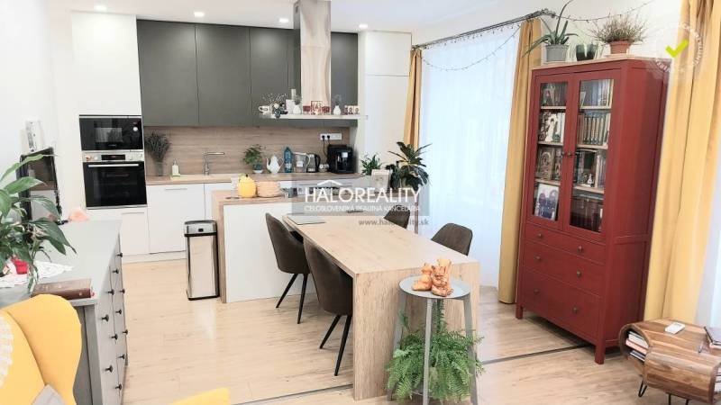 Interior of a kitchen in a 3-room apartment with a dining table and a wooden decor floor.