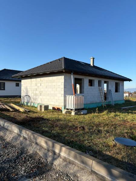 Unfinished family house in Vyšná Šebastová in Prešov with a black roof and construction material.