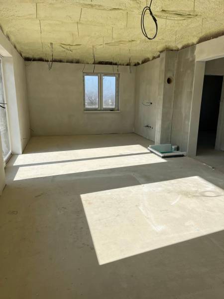 A spacious room in a family house on Vyšná Šebastová street with raw plaster and cables.