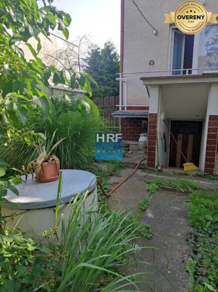 The garden of a family house on Vieska in Radošovce with a shelter and lush vegetation.