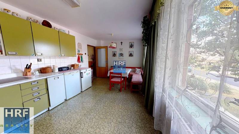 A kitchen in a family house with retro furniture, a table, a large window, and decorations.