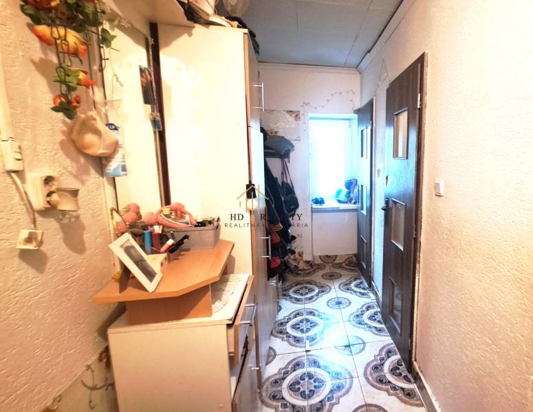 A hallway with lockers and decorations in a 2-room apartment. On the left, there are hangers, on the right, doors.