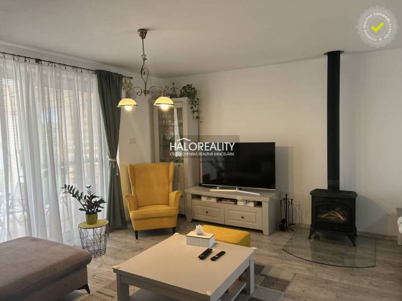 Living room in a family house with a fireplace, yellow armchair, and television.