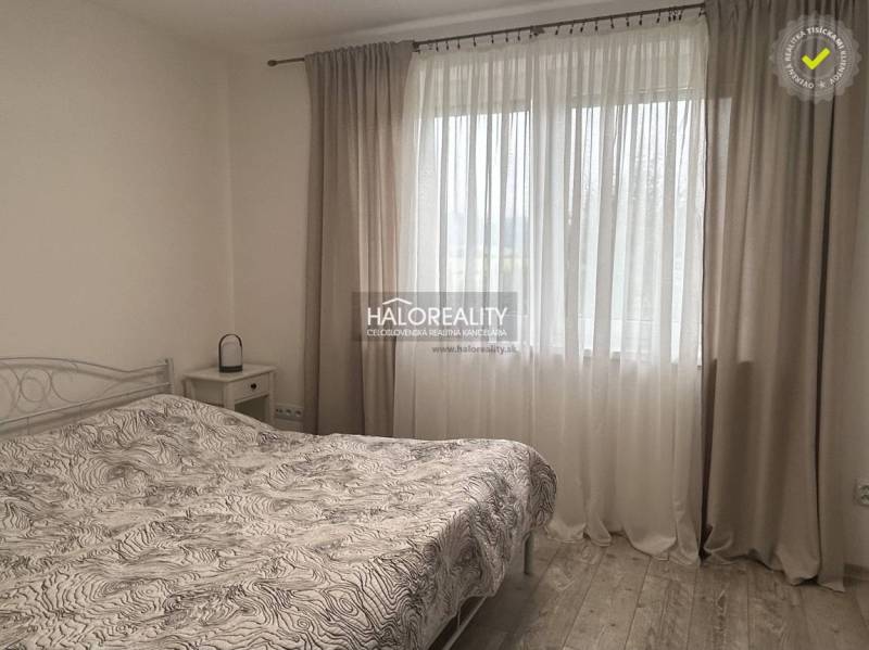 Bedroom with a bed and curtains in a family house, bright atmosphere.