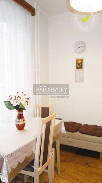 Dining area with a table, a plant, and chairs in a 3-room apartment, floor with wood decor.