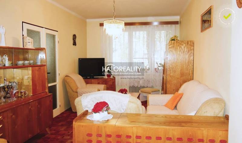 Living room in a 3-room apartment, floor with wood decor, wooden furniture, cozy armchairs.