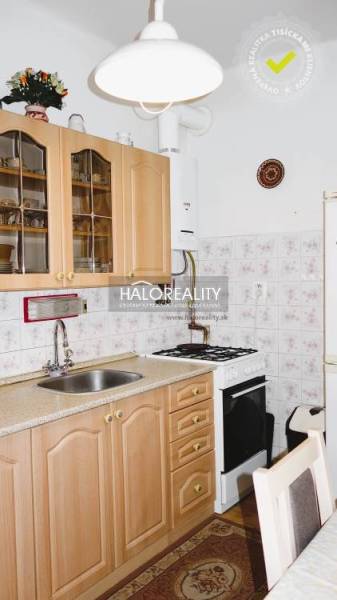 A kitchen in a 3-room apartment with wooden cabinets and a gas stove, tiled wall.