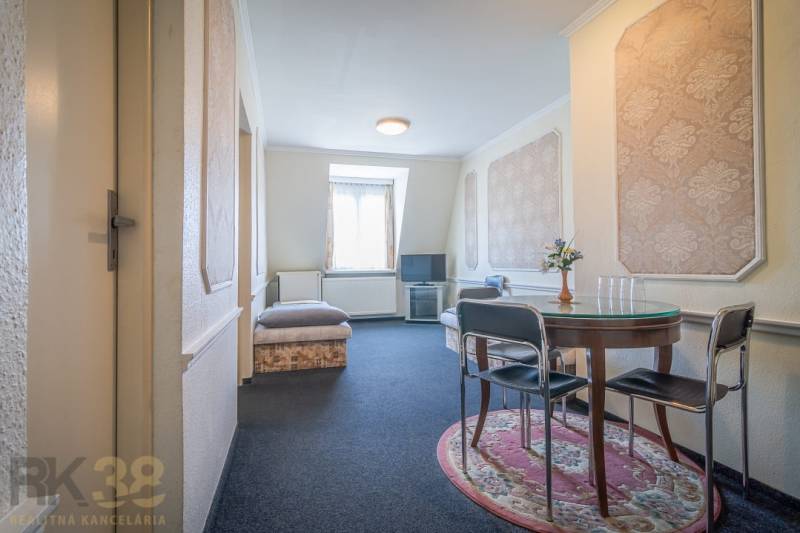 A room in hotels and guesthouses with a round table and a TV on a stand.