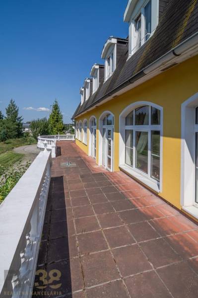 Yellow building with attic windows and a terrace in Hotels and Guesthouses in Poprad.