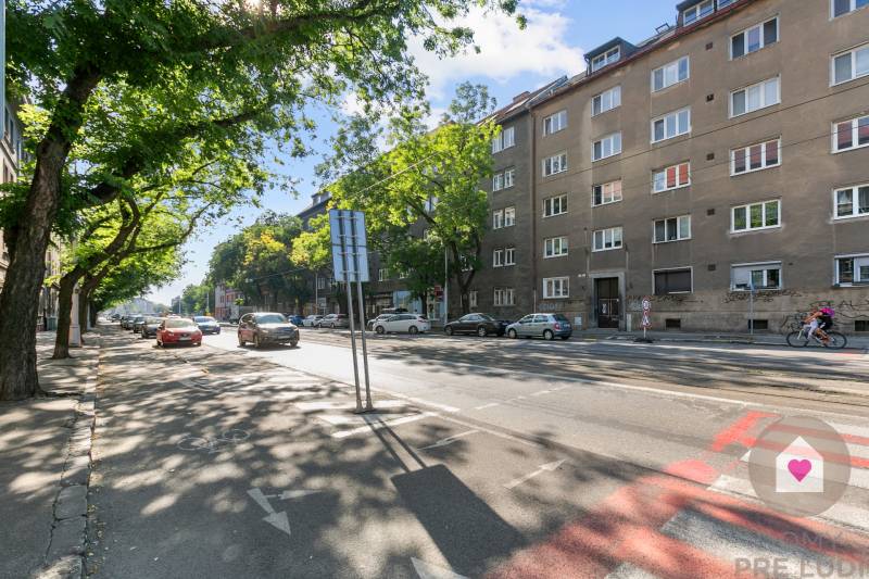 Vajnorská Street, Studio apartment in Bratislava - Nové Mesto, passing cars and a cyclist.